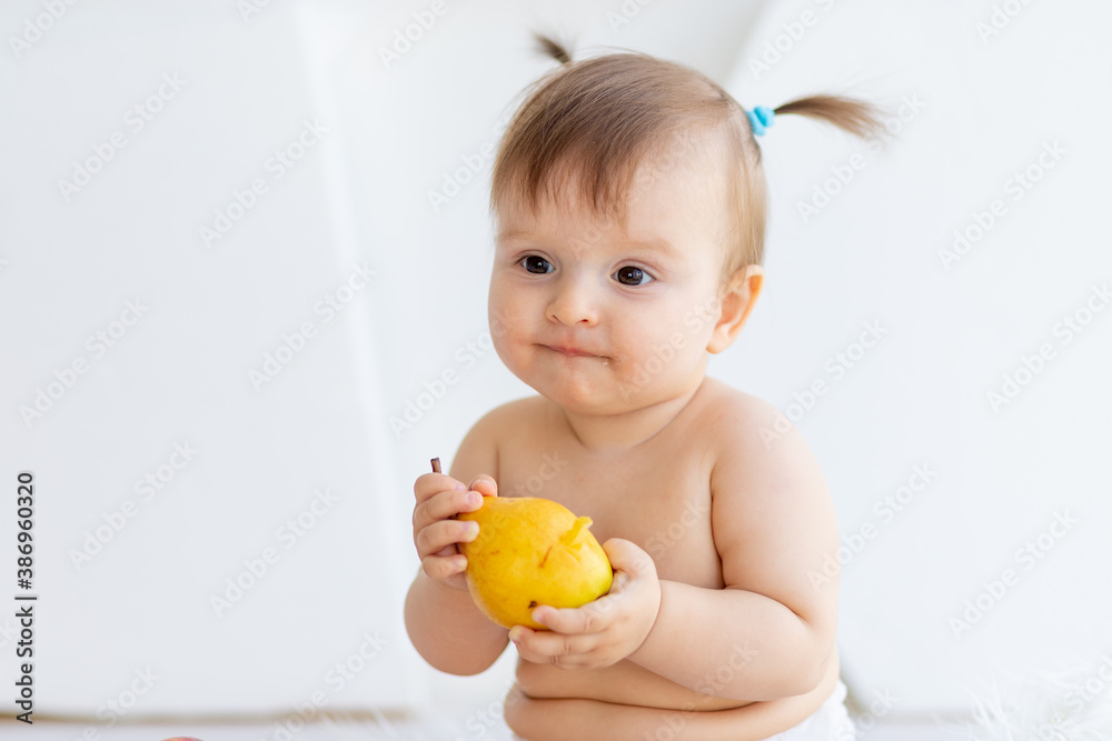 a little girl in a bright room sitting with a plate of fruit a little girl in a bright room sitting with a plate of fruit