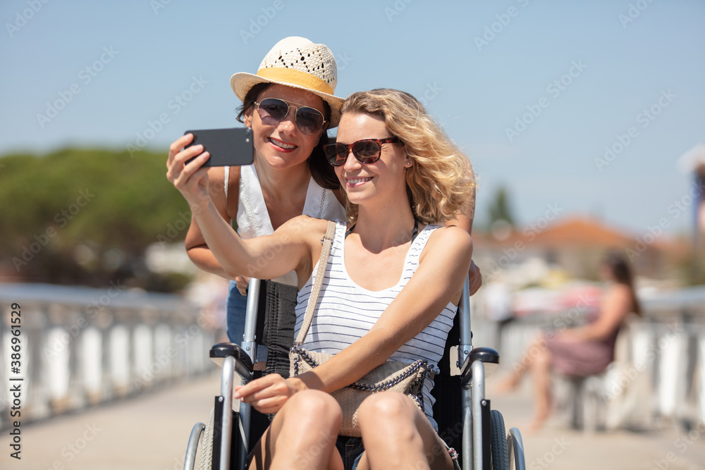 Naklejka premium active couple taking selfie with mobile phone on the beach