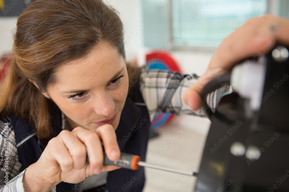 portrait of female engineer using a screwdriver portrait of female engineer using a screwdriver