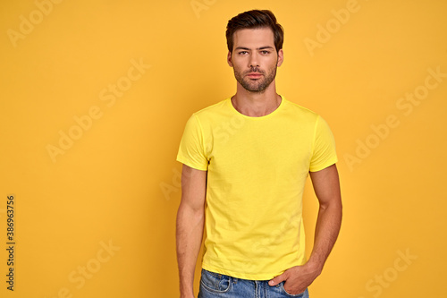 Photo of masculine man in yellow basic t-shirt isolated over yellow background