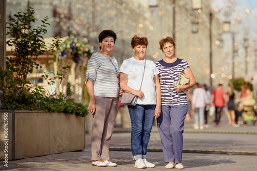 Aged woman wearing casual clothes while walking on the street.