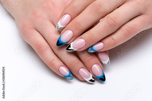 Multicolored French manicure on long sharp nails close-up on a white background. Blue, black, white, silver extended manicure.