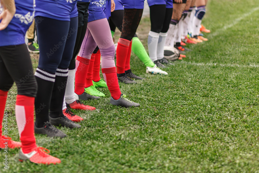 Fototapeta premium Legs of rugby women lined up on the field. Female team of athletes on the field
