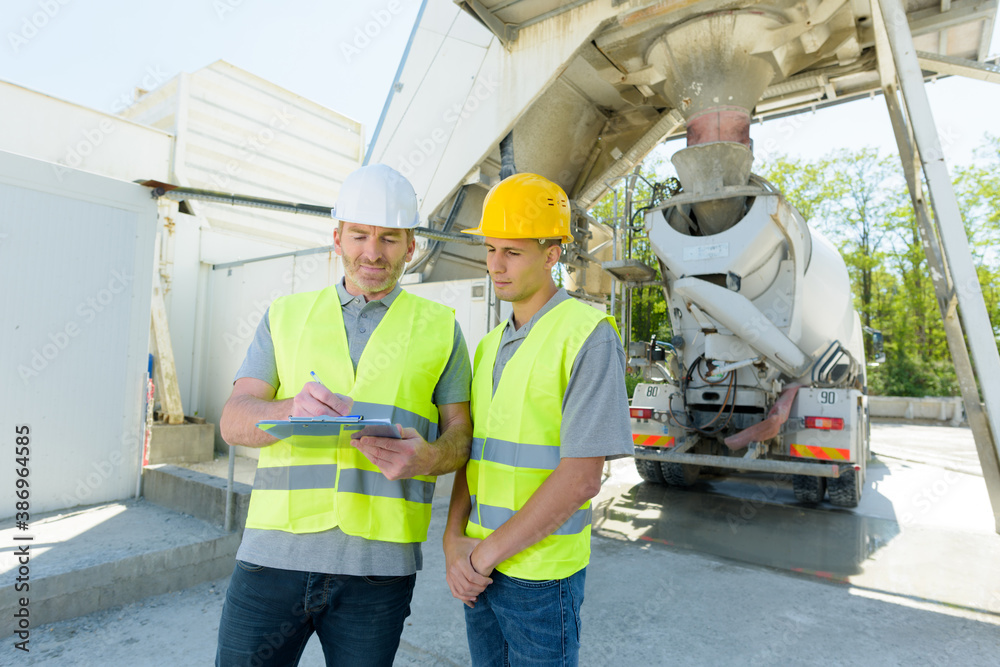 two civil engineer looking a blueprint in construction site two civil engineer looking a blueprint in construction site