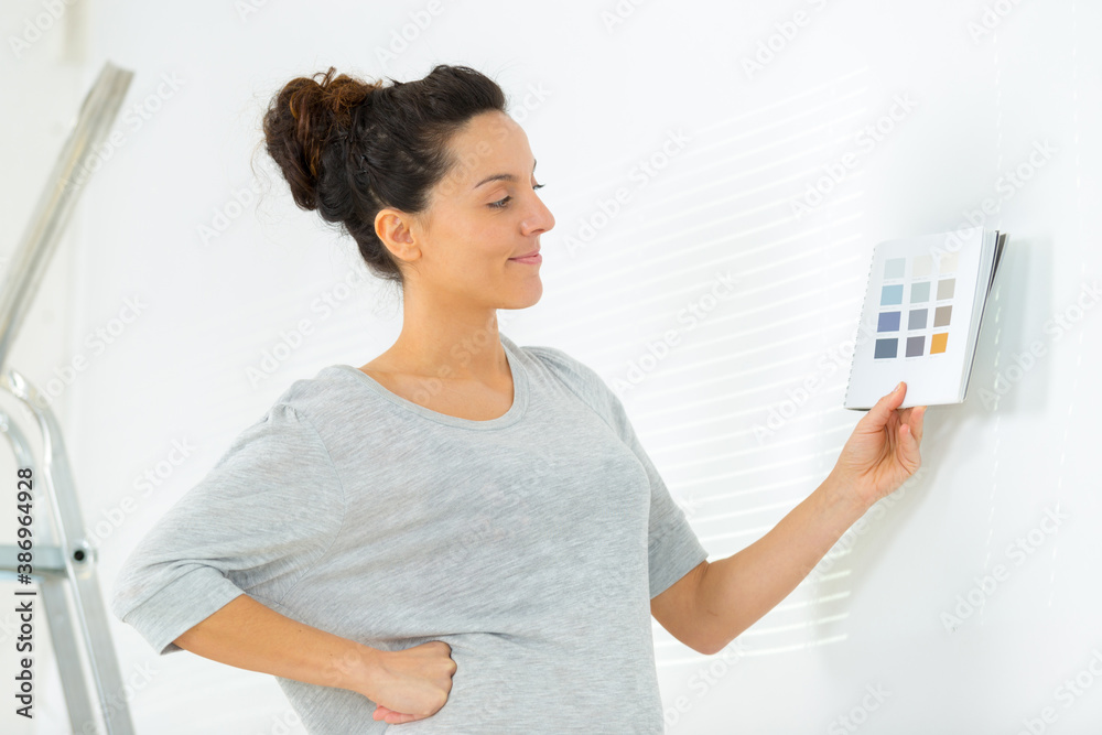 cheerful woman choosing colors to paint a room cheerful woman choosing colors to paint a room