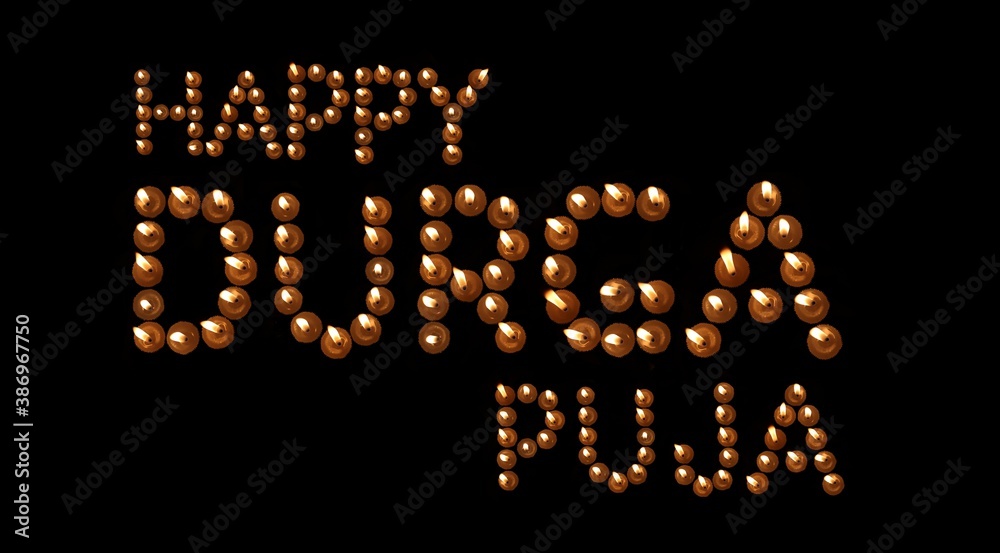 Happy Durga Puja Wishing Written Burning Candles in Black Background