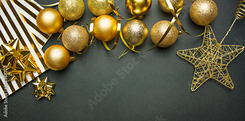 Christmas gold balls and decorations on a dark background. New Year decor. Christmas background. Copy space.