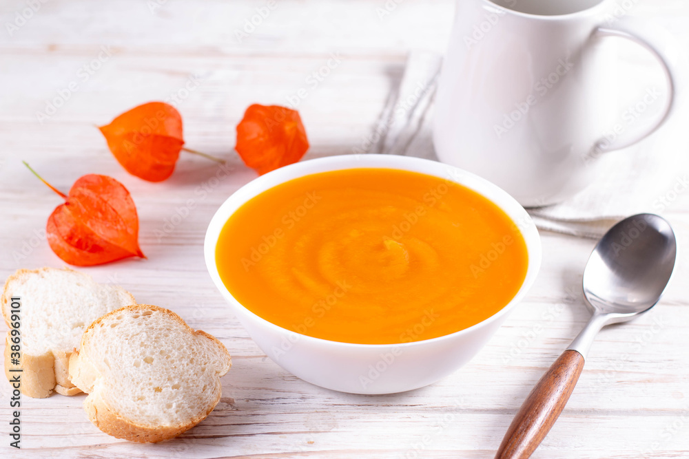 Pumpkin and carrot soup on a white plate. Vegetarian food concept. Pumpkin and carrot soup on a white plate. Vegetarian food concept.