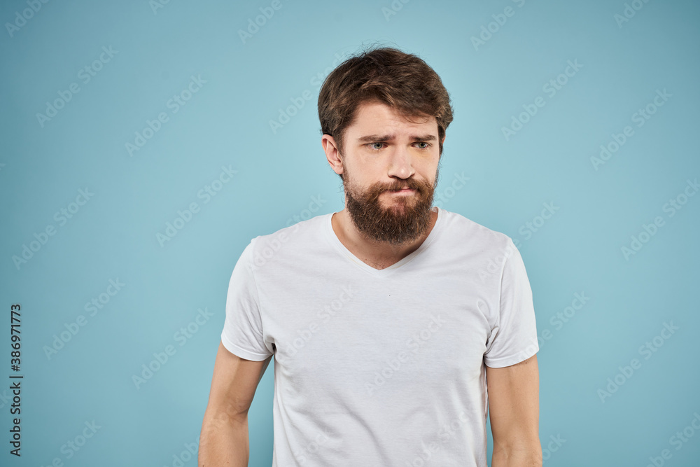 Man in white t-shirt emotions facial expression cropped view studio blue background lifestyle
