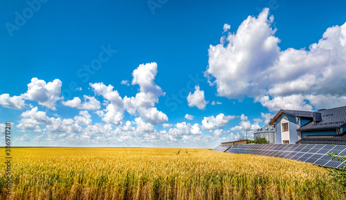 solar power plant with panels near a wheat field and cloudly sky