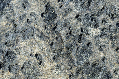 Porous rock structure of dark basalt stone texture background.