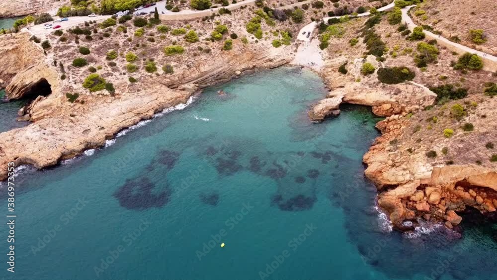 Aerial view of the rocky beach. Blue transparent sea water.