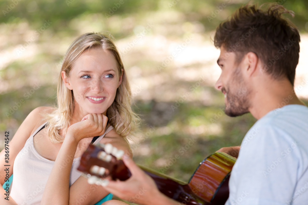 man playing guitar to girlfriend man playing guitar to girlfriend