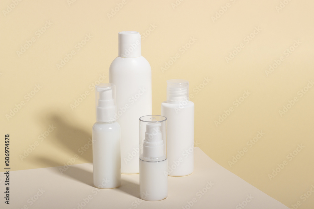 Set of white cosmetic bottles and jars with hard shadows. Home and beauty salon care concept