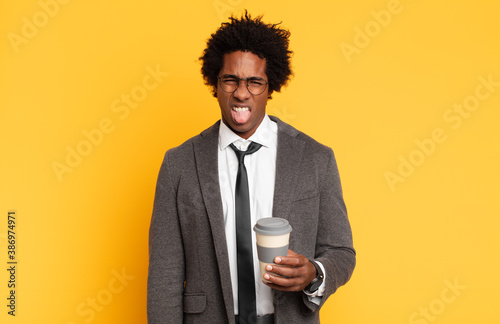 young black afro man feeling disgusted and irritated, sticking tongue out, disliking something nasty and yucky