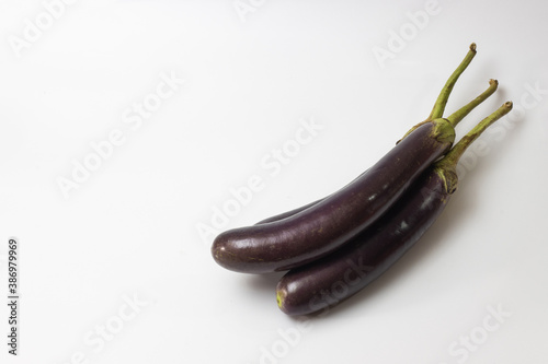 Three fresh eggplants on the corner of the white background photo