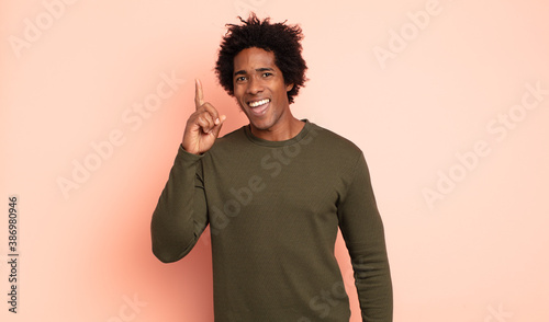 Photos young black afro man feeling like a happy and excited genius after realizing an