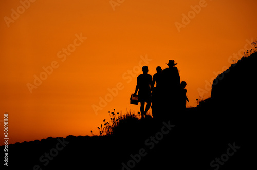 Holidaymakers retiring from the beach during sunset