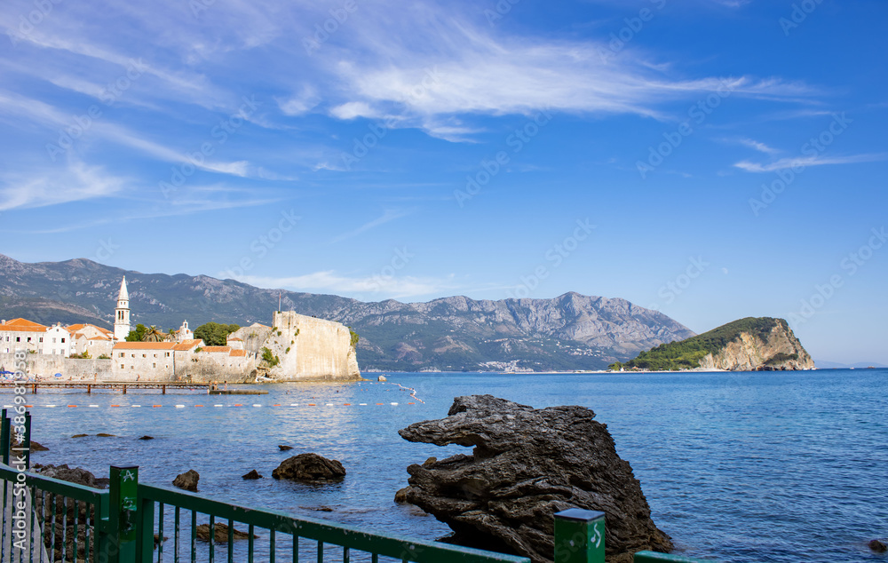 Seascape. Mountains, island and old town on the horizon. Rocky coast of the adriatic sea