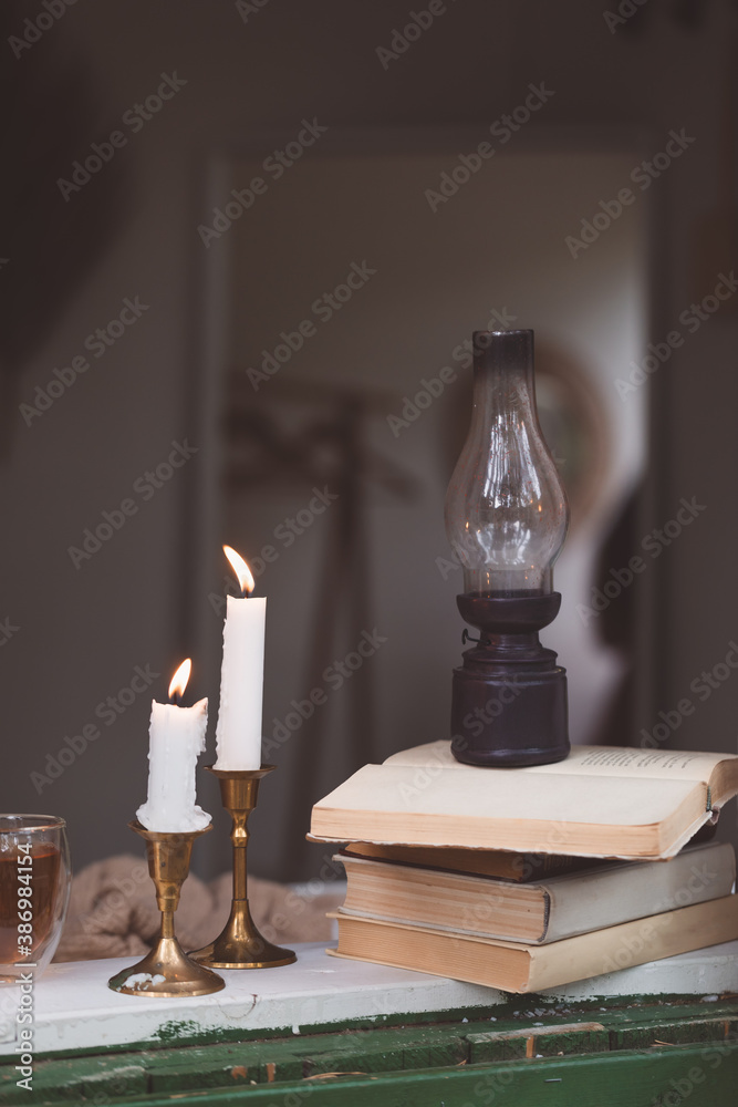 Warm and cosy hygge concept beige sweaters, books, candles windowsill Warm and cosy hygge concept beige sweaters, books, candles windowsill