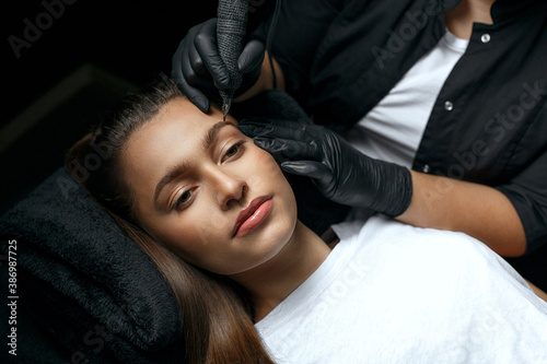 Makeup artist applying eyebrow permanent makeup
