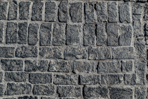 Old paving stone mosaic pattern. Pavement texture. Gray cobblestone sidewalk background. Rough granite textured road construction. Paved cobble exterior. Paving city street