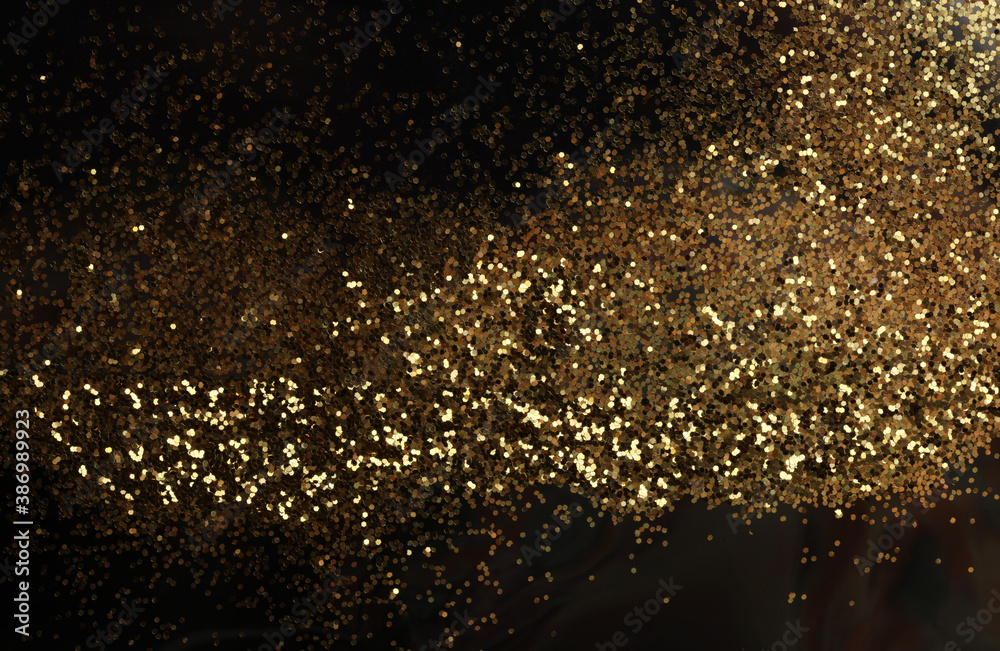 Gold (bronze) glitter shine dots confetti on black. Abstract light blink sparkle horizontal backgound.