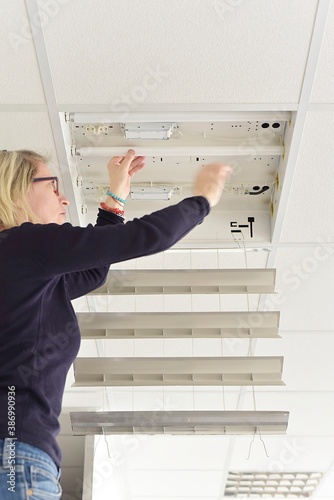 woman exchanges neon fluorescent lamps	