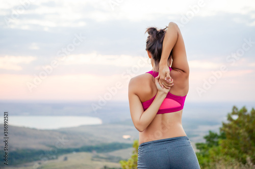 young pregnant woman does yoga outdoors. Yoga at sunset