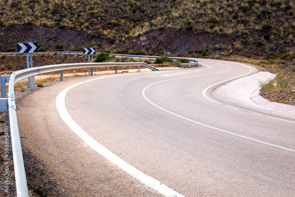 Obraz premium A dangerous and curvy two-lane asphalt road on the mountains near Cabo de Gata-Níjar Natural Park in the southeastern corner of Spain