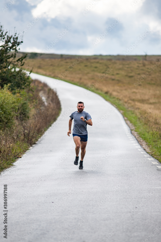 young man running on country road