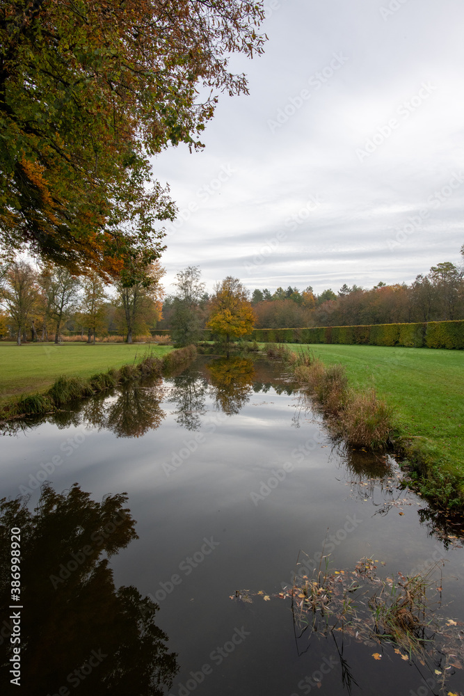 herbstlich gefärbte Laub Bäume im Park mit Spiegelung im Wasser herbstlich gefärbte Laub Bäume im Park mit Spiegelung im Wasser