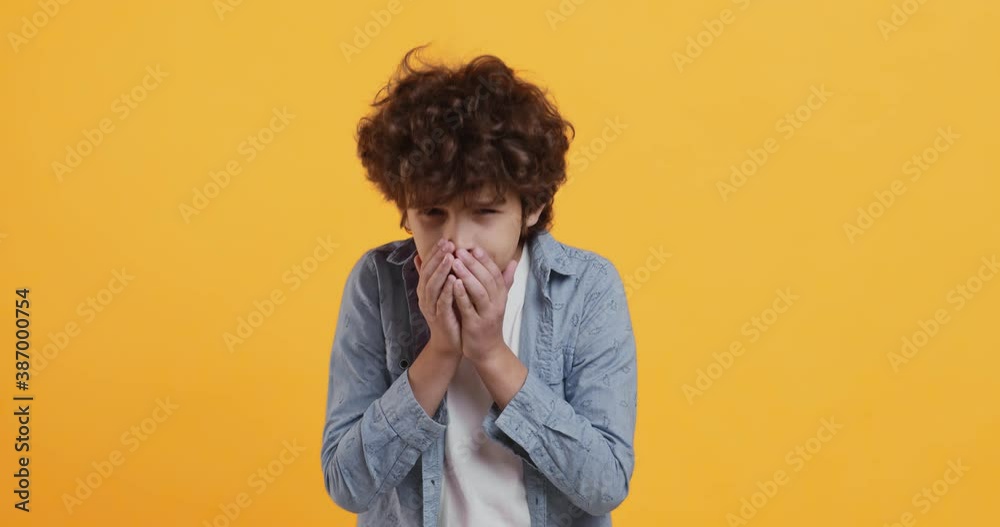 Allergy concept. Studio portrait of little boy sneezing and looking at camera