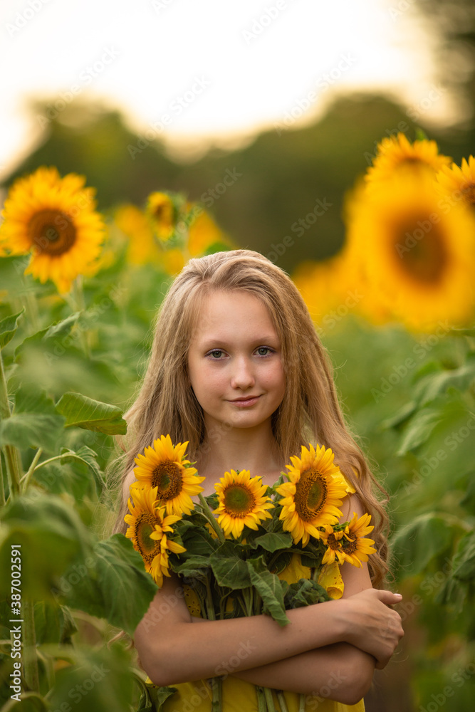 Cute teenage girl in yellow dress on the field with sunflowers Cute teenage girl in yellow dress on the field with sunflowers
