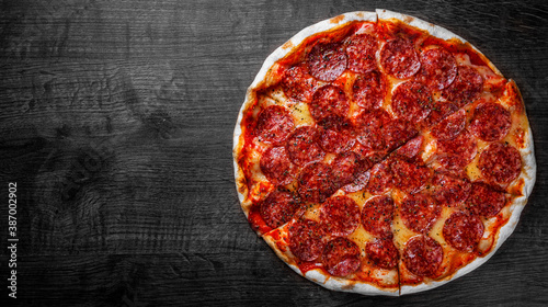 Pepperoni Pizza with Mozzarella cheese, salami, Tomato sauce, pepper, Spices. Italian pizza on wooden table background