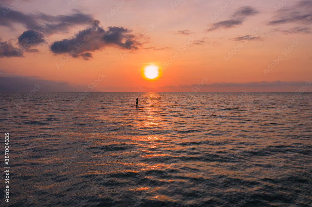 sunset over the sea with and paddle board