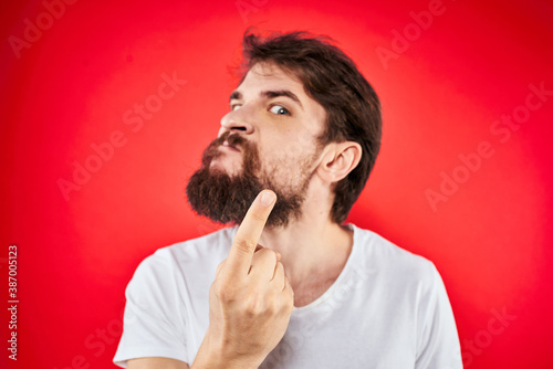 bearded man gesturing with hands white t-shirt emotions facial expression aggression red isolated background