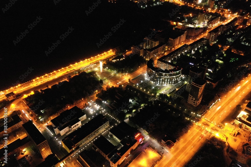 The night city's panarama, the city streets are illuminated by bright yellow lanterns, shooting from a drone.