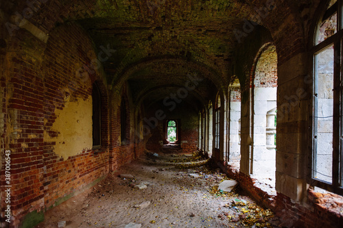 Dark corridor of old ancient abandoned red brick ruined historical building