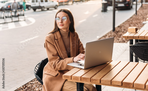 Successful businessman working at laptop. Business woman working. Sales woman working using her laptop while writing text. Businesswoman in glasses working on-line. Mobile technology. photo