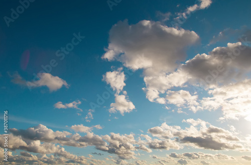 Dramatic evening summer or early autumn warm bright blue cloudy sky background.