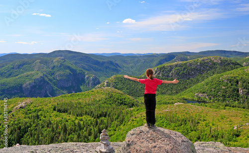 Hiker girl enjoying the scenery on the top of Mont-du-Lac-des-Cygnes in Grand Jardins National Park, Quebec, Canada photo