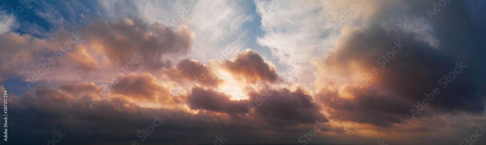 Dramatic panorama of the sunset sky with clouds in the evening.