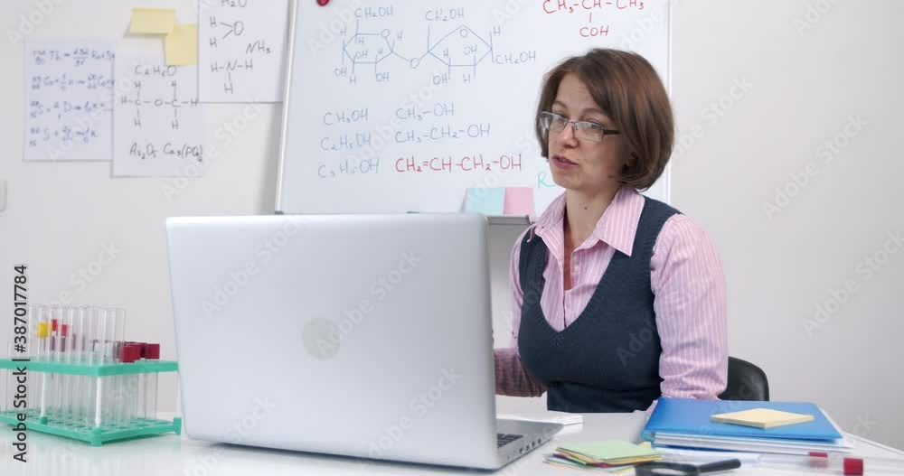 The teacher leads an online lesson for schoolchildren or students. Female professor communicates via video conference. E-learning. Distance learning chemistry. The teacher leads an online lesson for schoolchildren or students. Female professor communicates via video conference. E-learning. Distance learning chemistry.