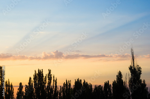 Landscape with dramatic light - beautiful golden sunset with saturated sky and clouds.