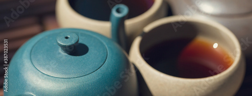 Chinese tea ceremony. Ceramic teapot made of clay and bowls on a wooden background.