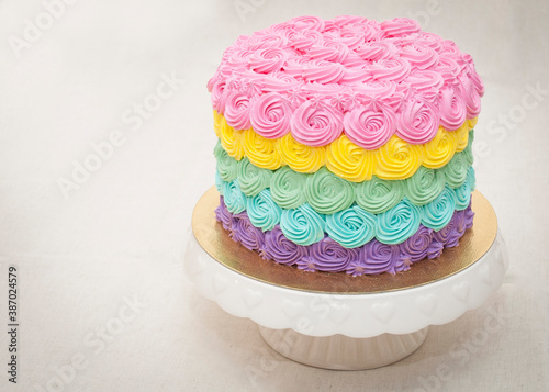 Round cake decorated with rainbow (ID: 387024579)
