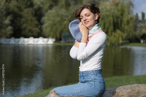 Young woman in the park. Cute girl portrait in french style.