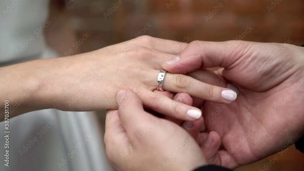 The groom puts a ring on the bride's finger at the wedding ceremony The groom puts a ring on the bride's finger at the wedding ceremony