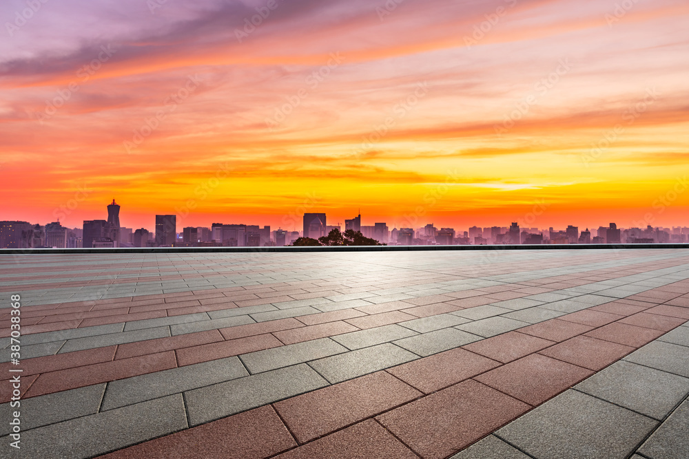 Empty square floor and city skyline with buildings in Hangzhou at sunrise.